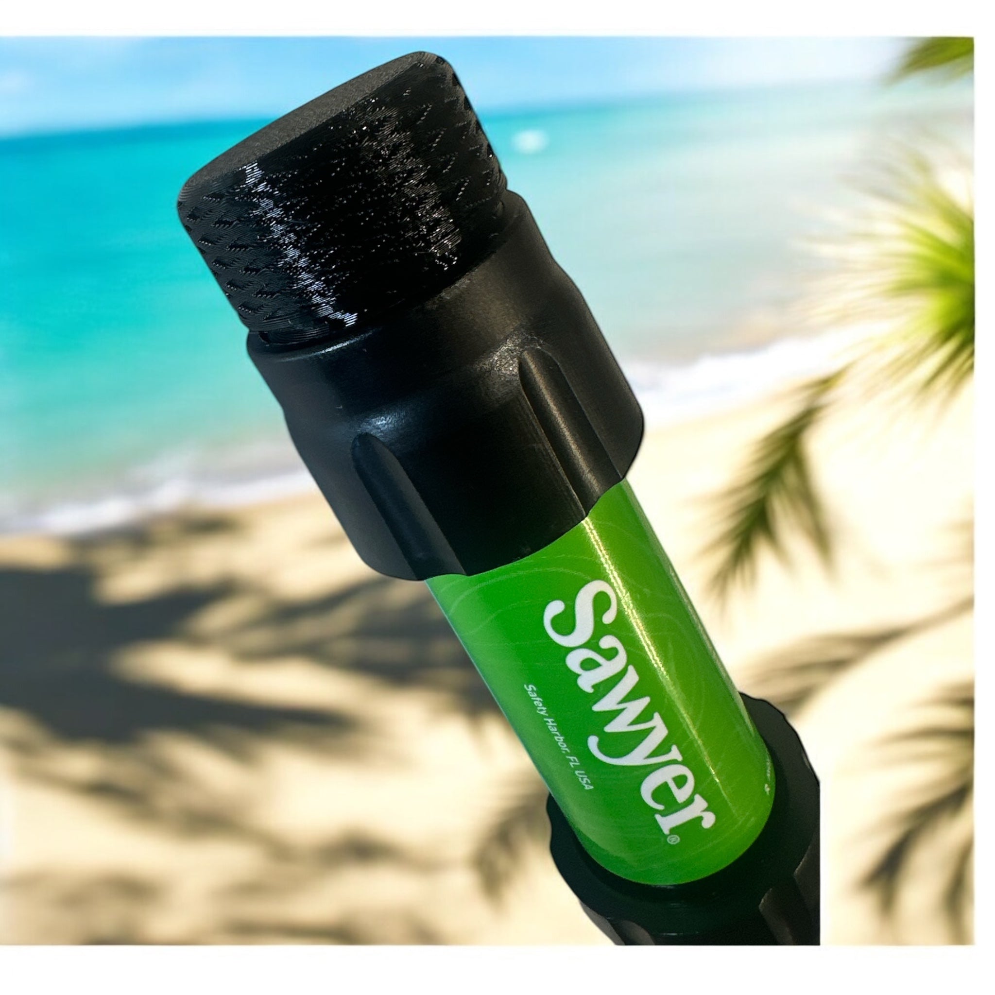 Närbild av Sawyer vattenfilter med en adapter på toppen, placerad mot en strandbakgrund. Visar hur adaptern förbättrar flaskkompatibilitet.